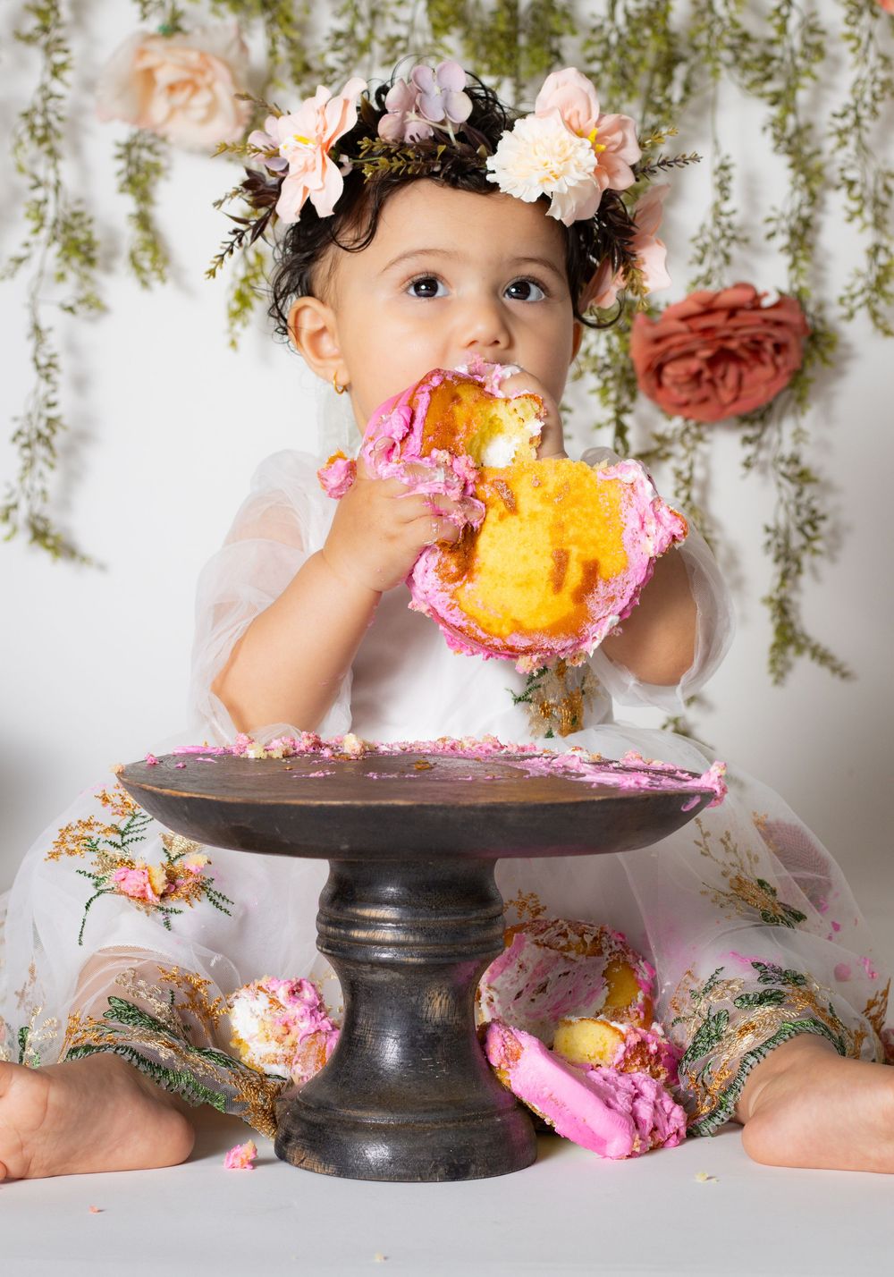 “Adorable one-year-old in a flower crown during a floral garden-themed cake smash session – Lake Nona studio.”