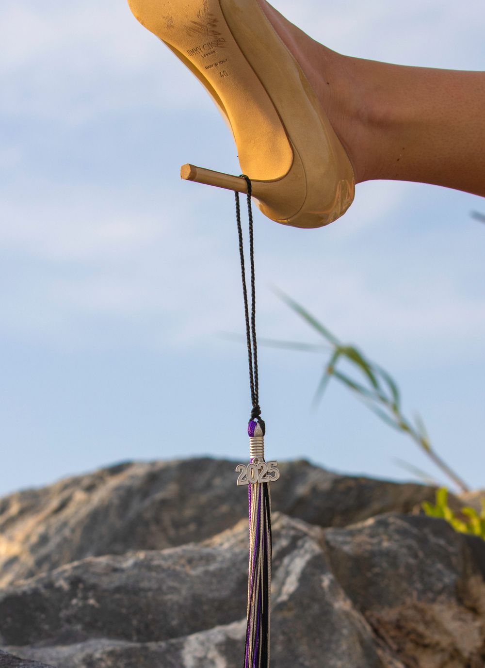 Heel with tassel: Grad session at the beach, gold heel with 2025 tassel hanging—chic, bold, and symbolic of the journey ahead