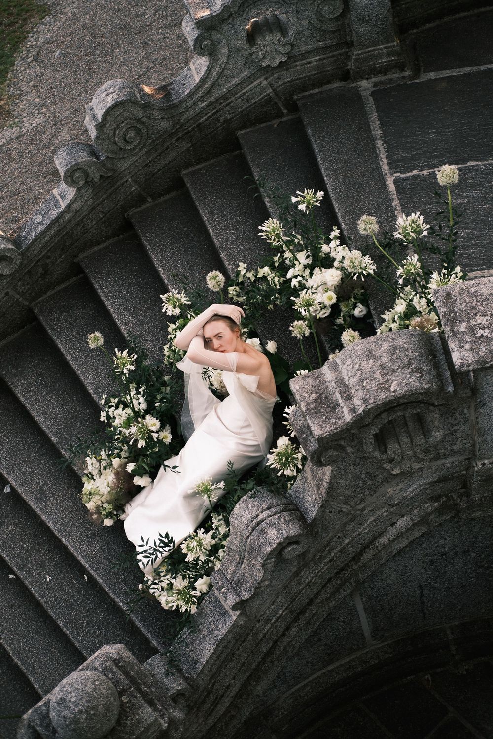 Lake Como bridal portrait on stone steps, romantic candid destination wedding photography in Italy.