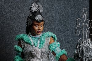 Photography Oil painting Calabar bride in a traditional costume featuring teal fabric and silver ornaments and a rod.