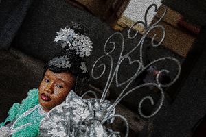 Photography Oil painting  Decorative silver swirls and ornaments complement a teal and silver costume worn by a calabar bride.