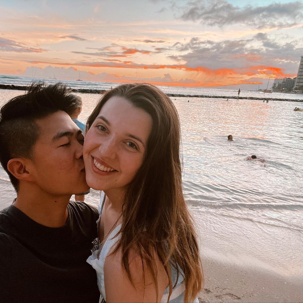 Jess and her husband smiling together during their beachside wedding celebration