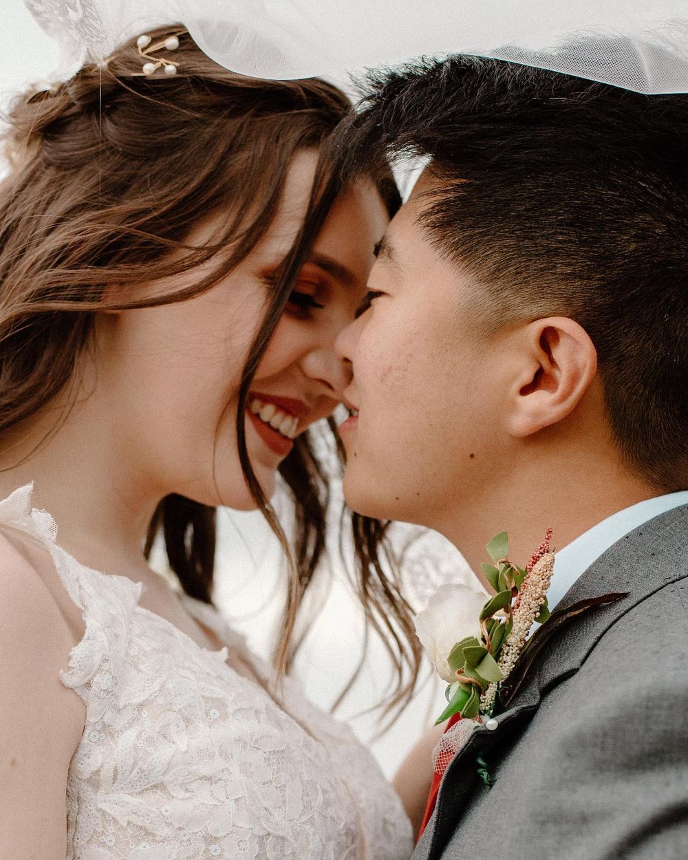 Bride and groom smiling forehead to forehead on their wedding day