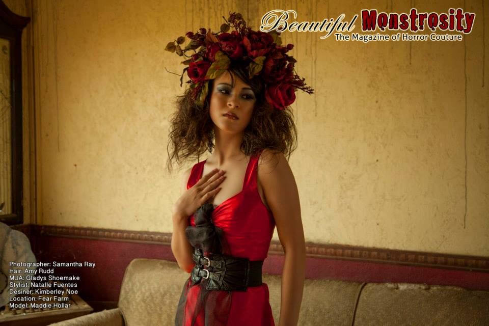 Model in red dress with floral crown poses in vintage setting with dramatic lighting.