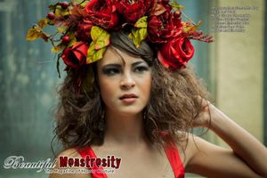 Fashion portrait with colorful rose crown and natural makeup against blurred background.