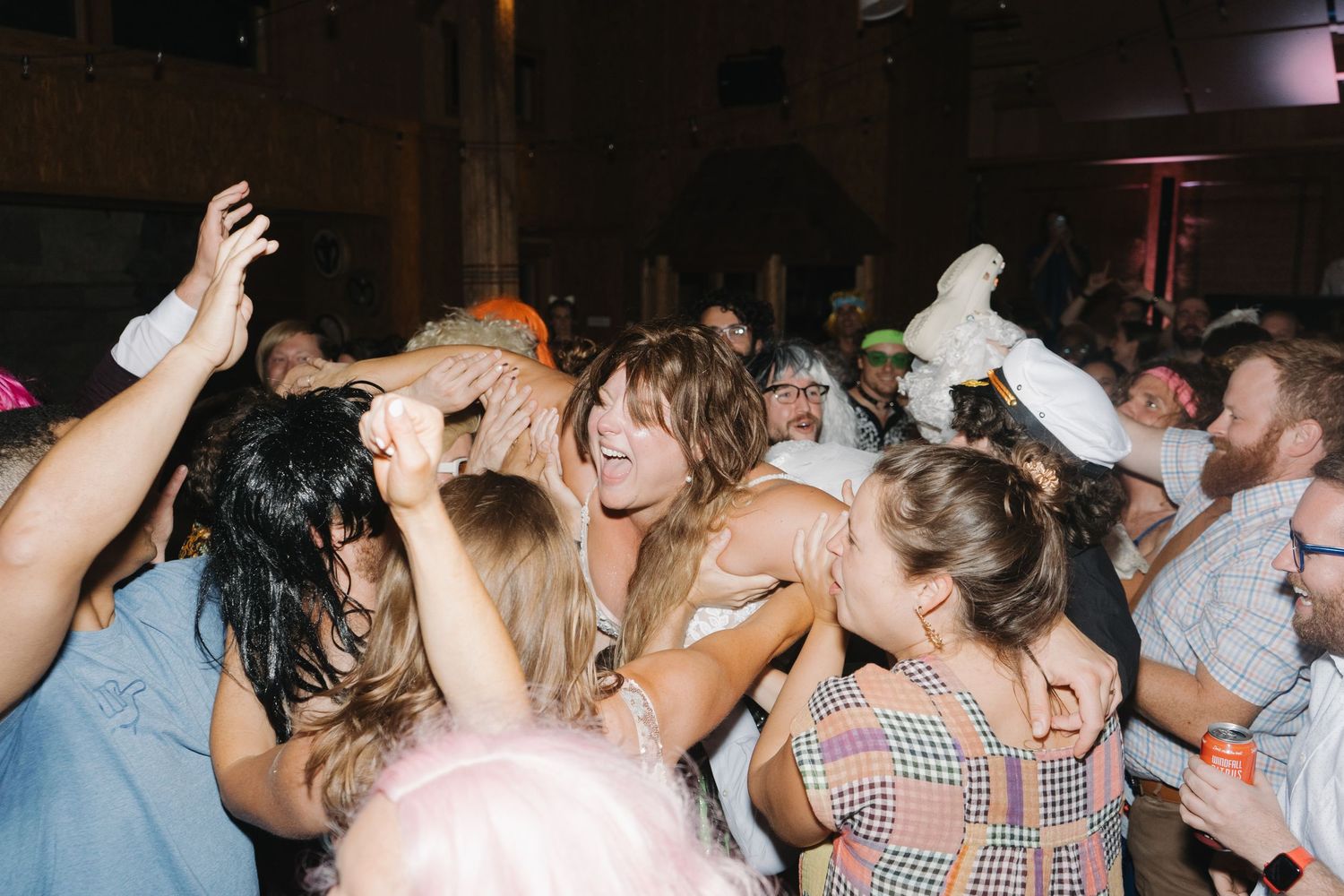 A crowded dance floor filled with energetic people dancing and moving together in a dark indoor venue.