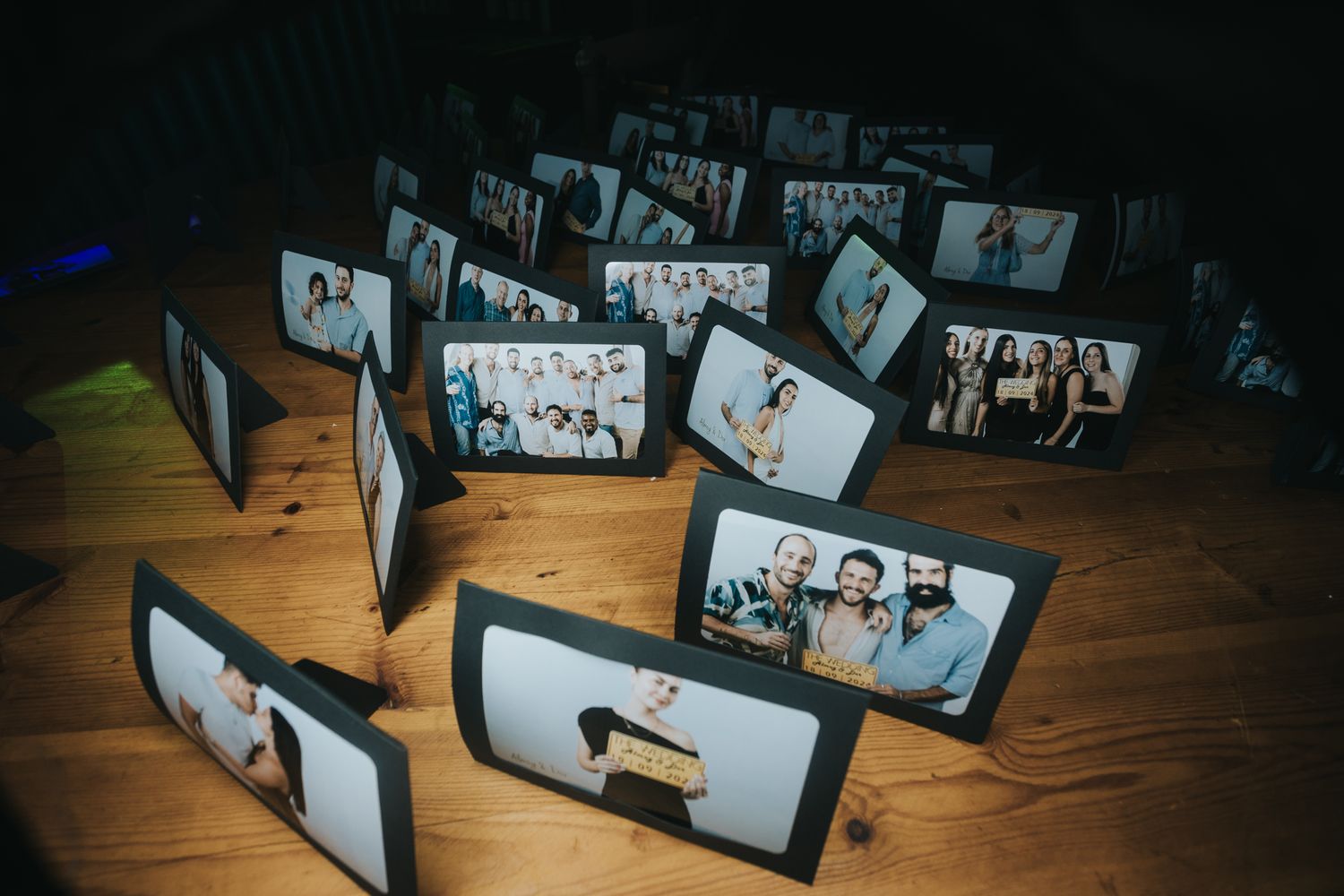 Wedding photo display with multiple framed pictures arranged on wooden surface.