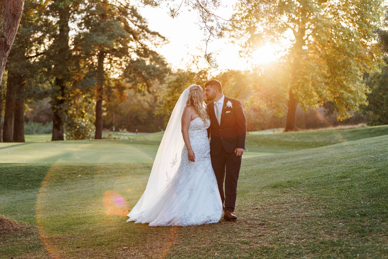 Black and white portrait of couple embracing outdoors with soft romantic lighting.