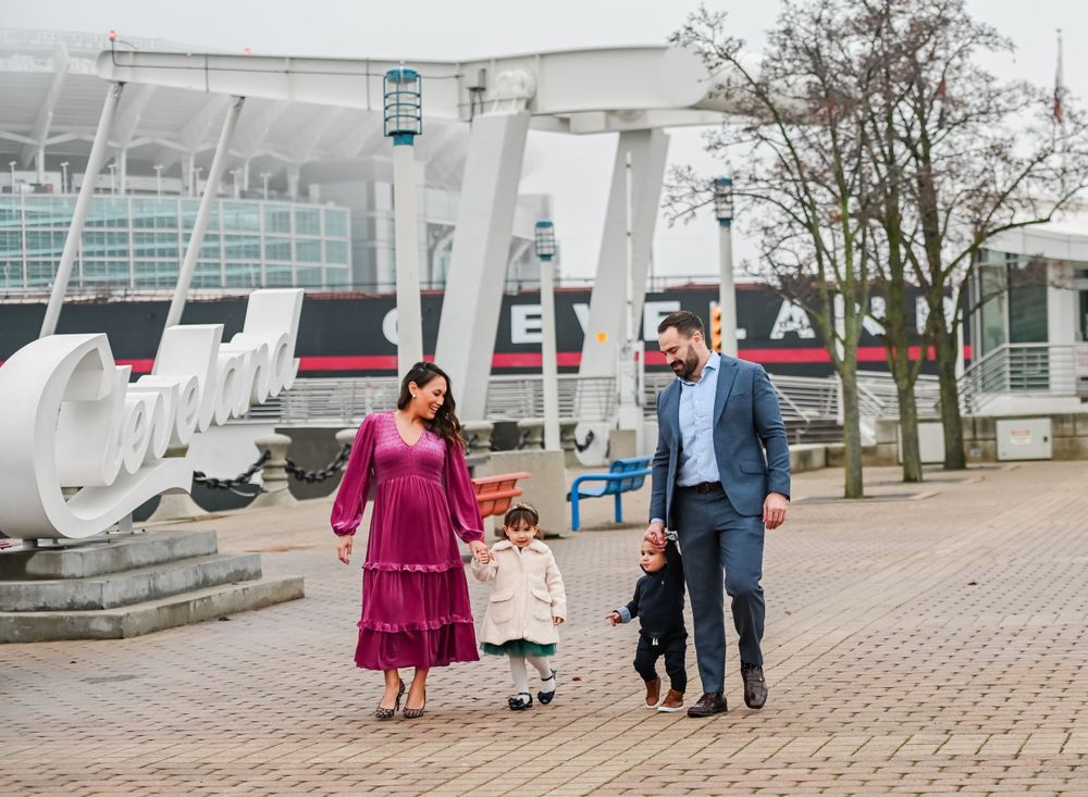 Family walking together along waterfront path near modern architectural features.