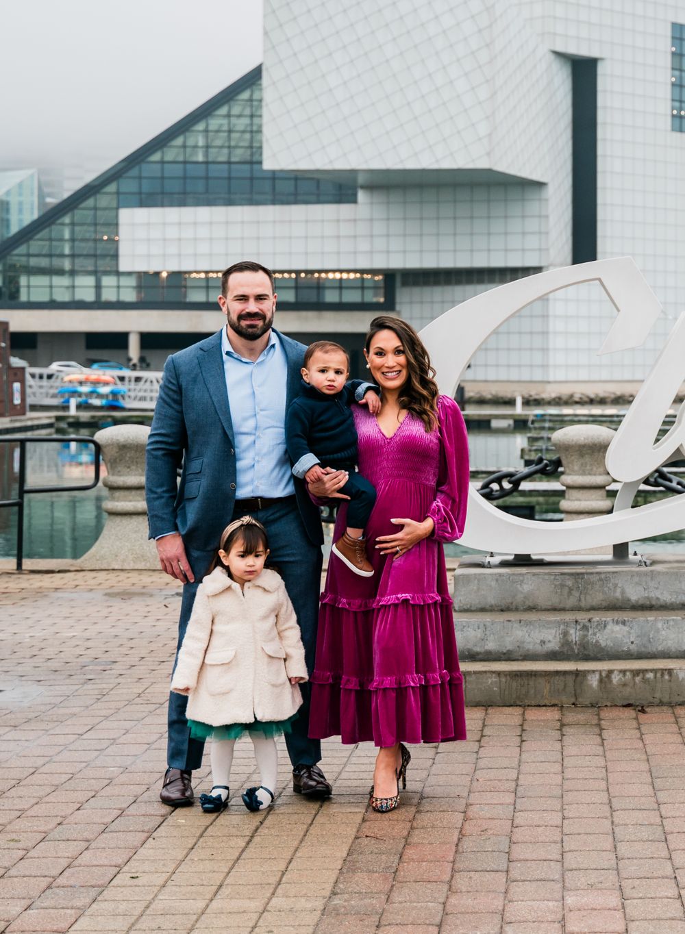 Family portrait outside modern architectural building with geometric white facade.