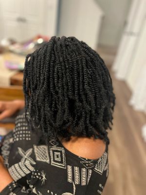 Close-up view of black yarn loc extensions and tribal pattern fabric.