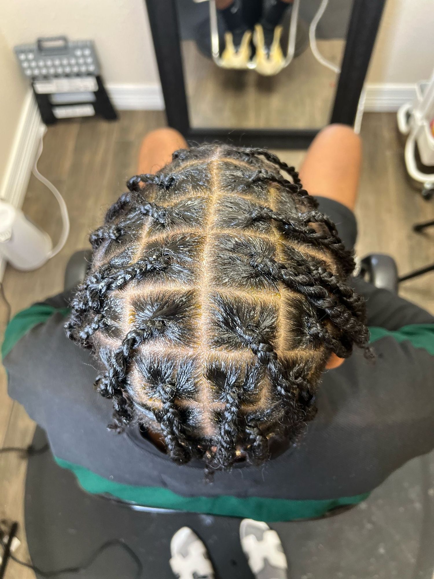 Close-up view of a neatly sectioned cornrow braided hairstyle showing precise parting and braiding technique.