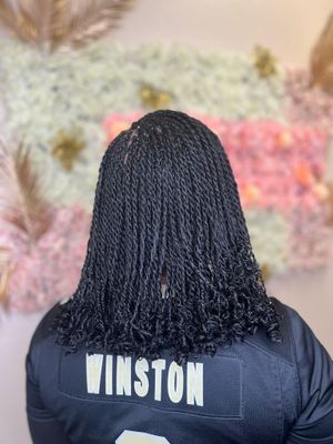 Back view of a person wearing black braids and a navy blue football jersey with 'WINSTON' printed on it.