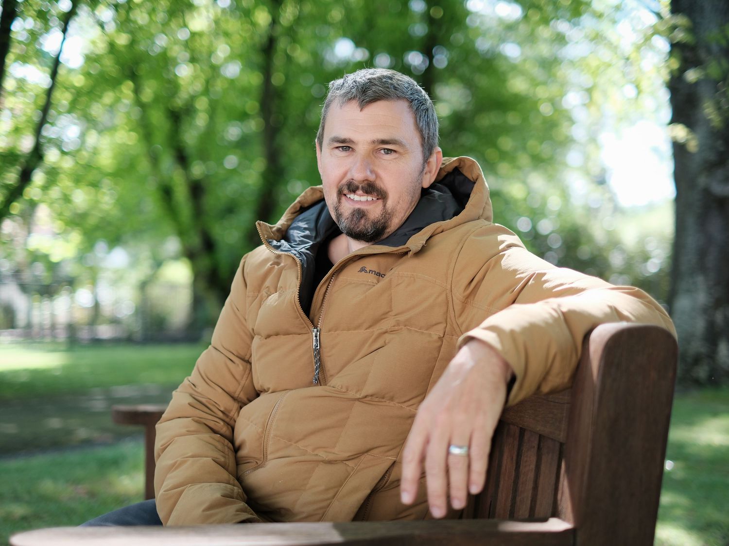 James O'Dea posing for a photo on a wooden bench in the Queen Mary Hospital at Hanmer Springs