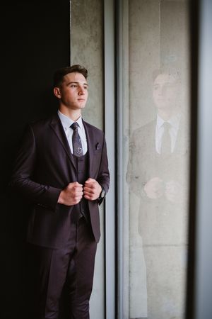 Young man adjusting his jacket and posing for his matric farewell photos.