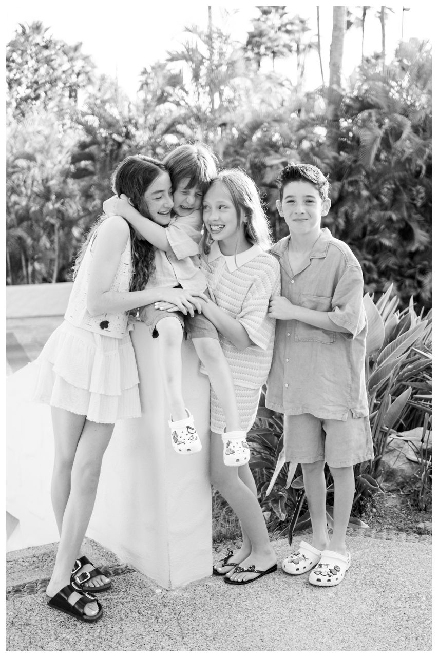 Black and white portrait of children sharing a group hug during a family photo session at St. Regis Punta Mita.