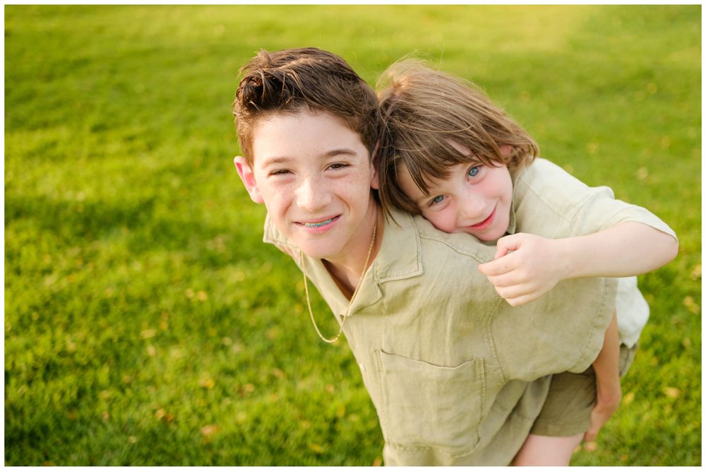Family members sharing a playful piggyback ride during a family photography session at St. Regis Punta Mita.