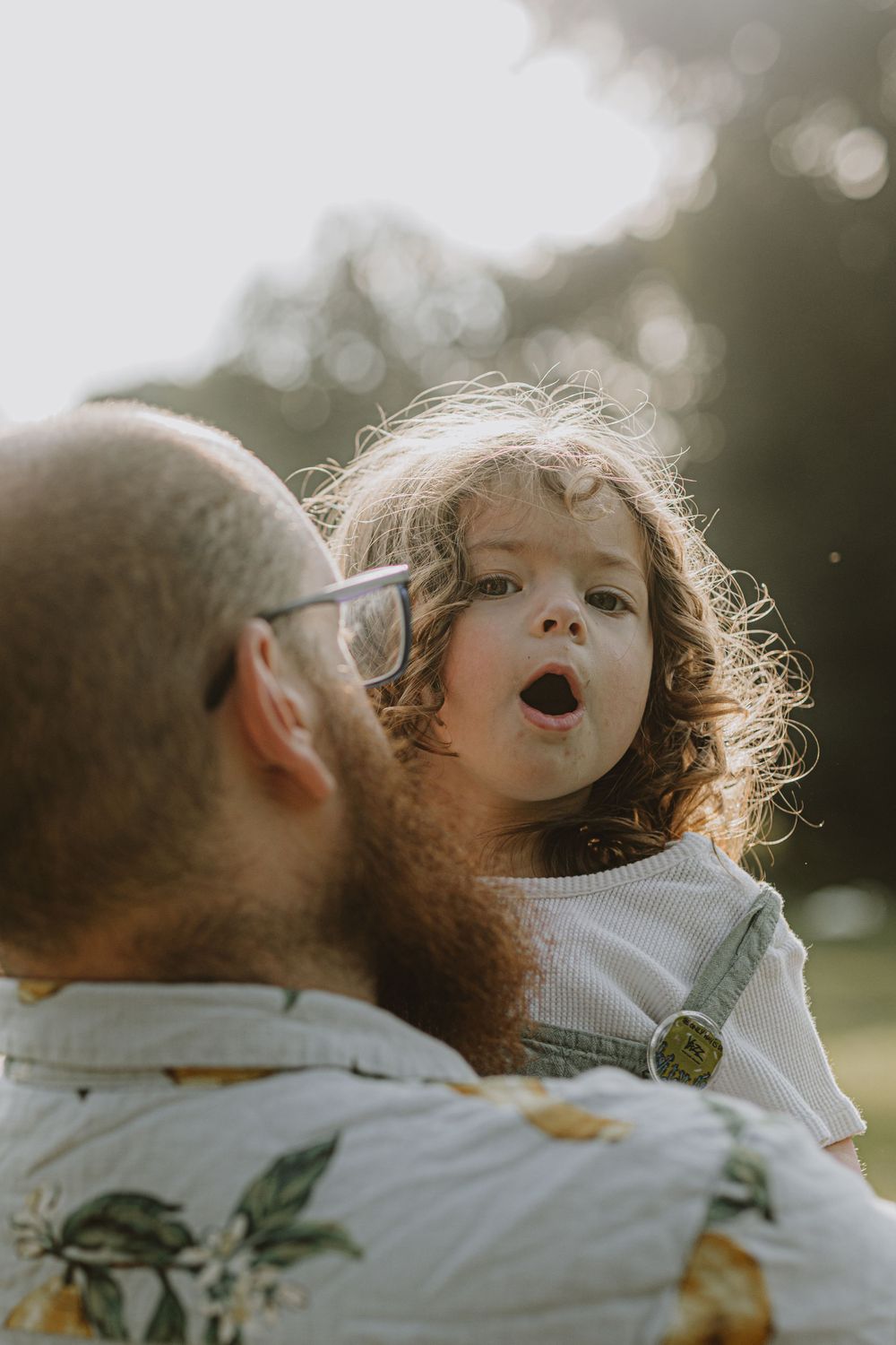 Close-up shot of a playful moment between parent and child in golden hour lighting.