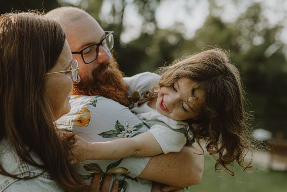 Intimate family moment captured during golden hour in an outdoor setting.