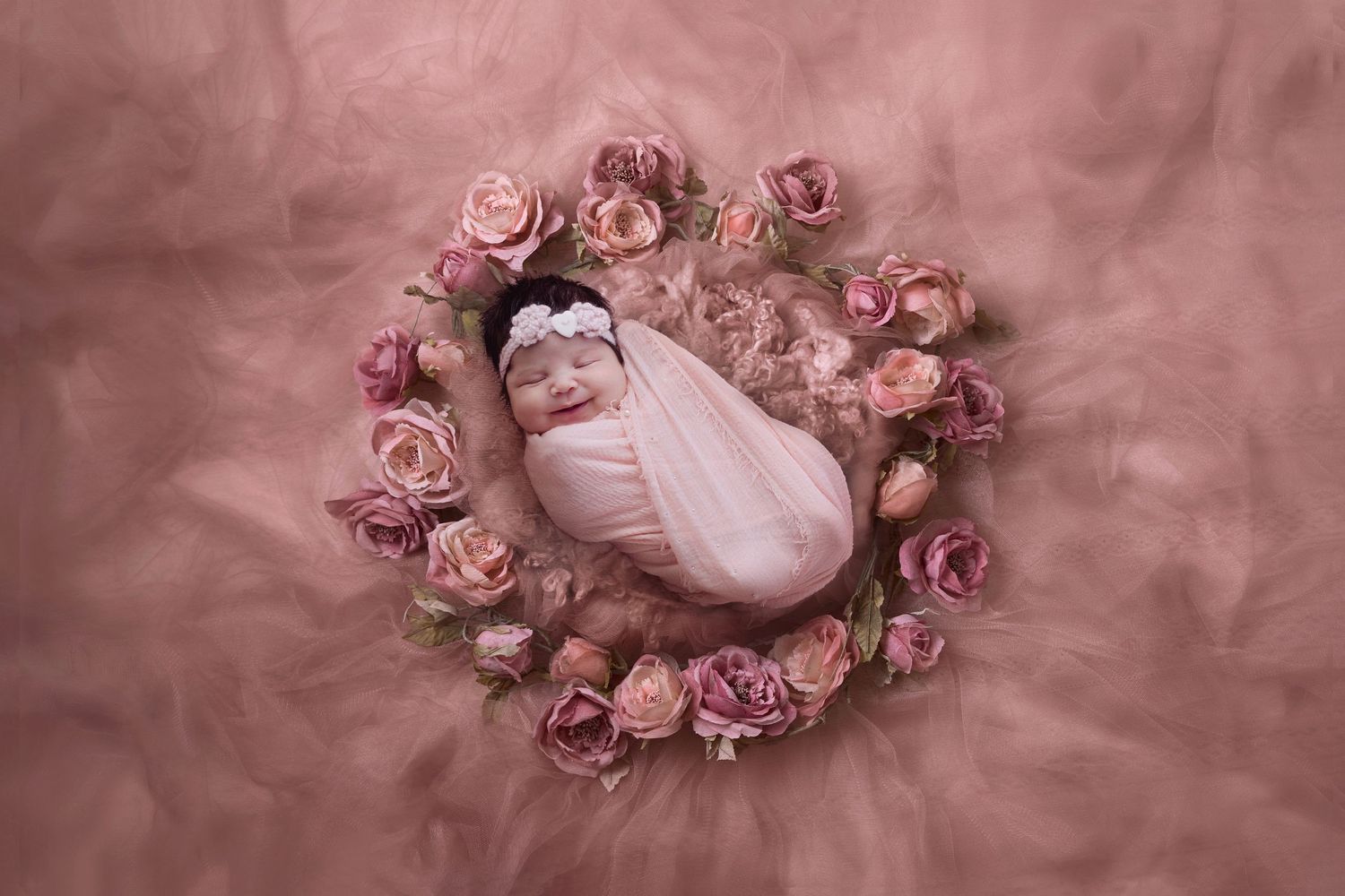 Delicate pink roses arranged in a circular pattern on a dusty rose background.