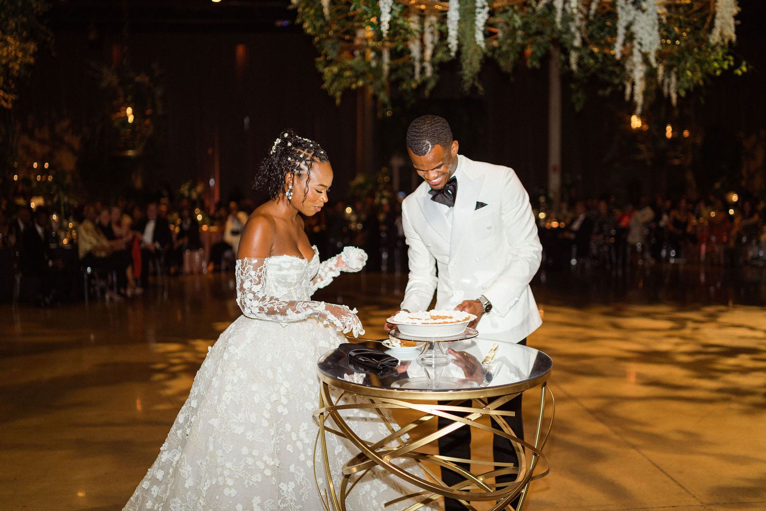 Newlyweds cutting their wedding cake together at an elegant reception.