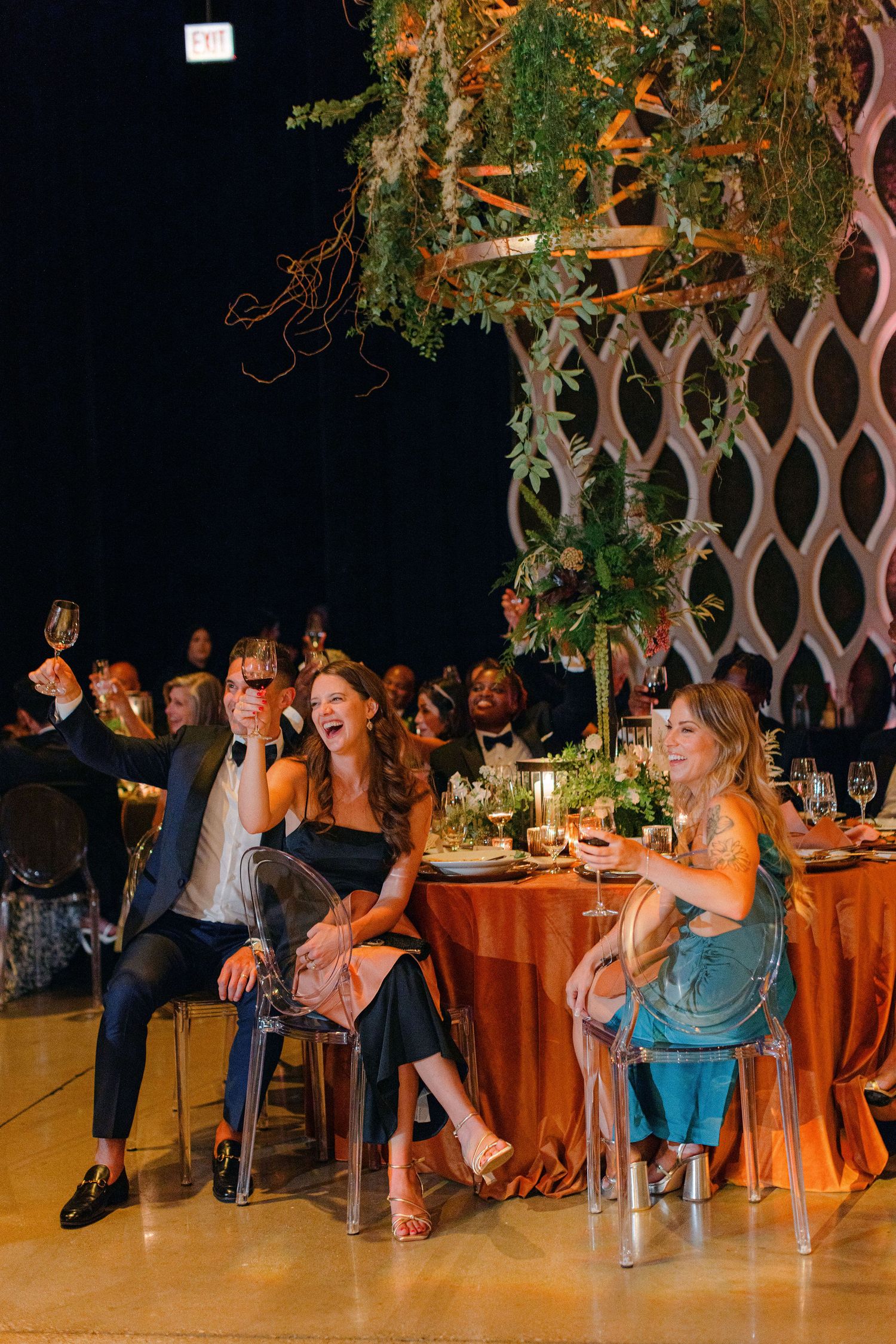 Wedding guests enjoying themselves at a reception with lattice decor and orange table settings.