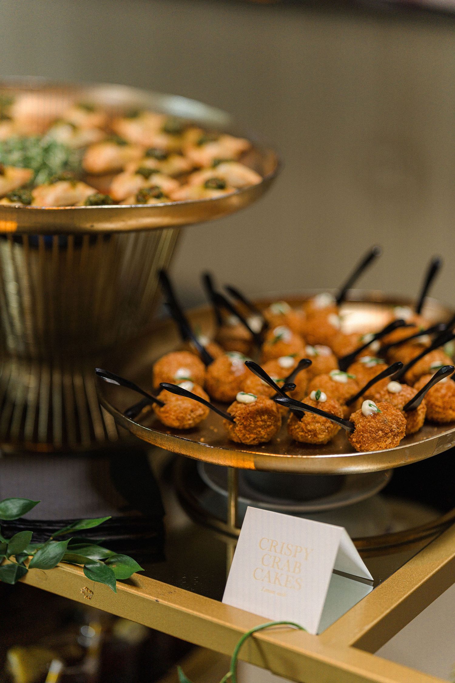 Gourmet appetizers served on elevated gold platters at an elegant event.
