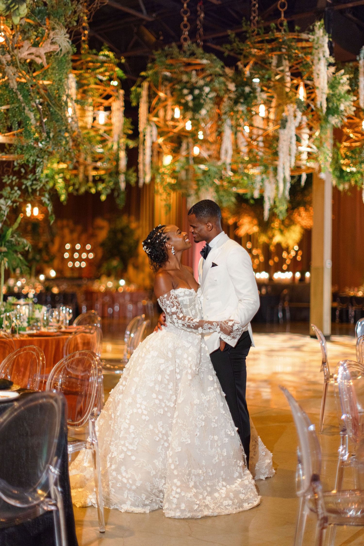 Romantic wedding couple sharing an intimate moment under hanging garden lights.