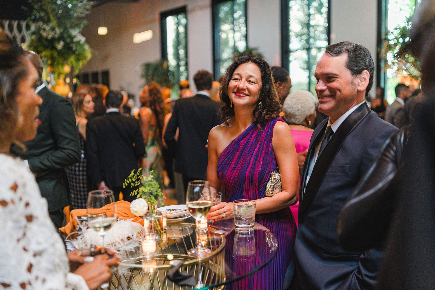 Wedding guests enjoying conversation and drinks at an elegant reception.