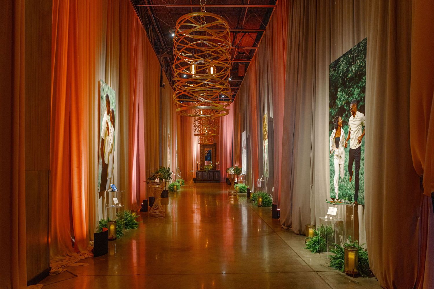 Long hallway decorated with draped fabric and chandelier lighting creating a dramatic entrance.