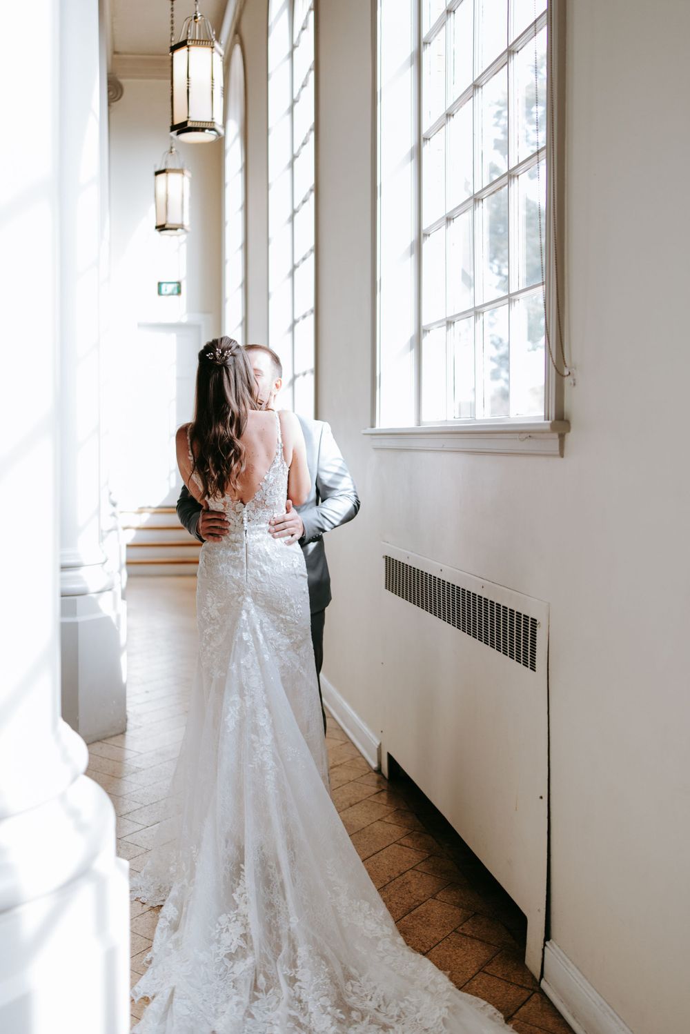 A romantic moment captured in an elegant church hallway with natural window light.