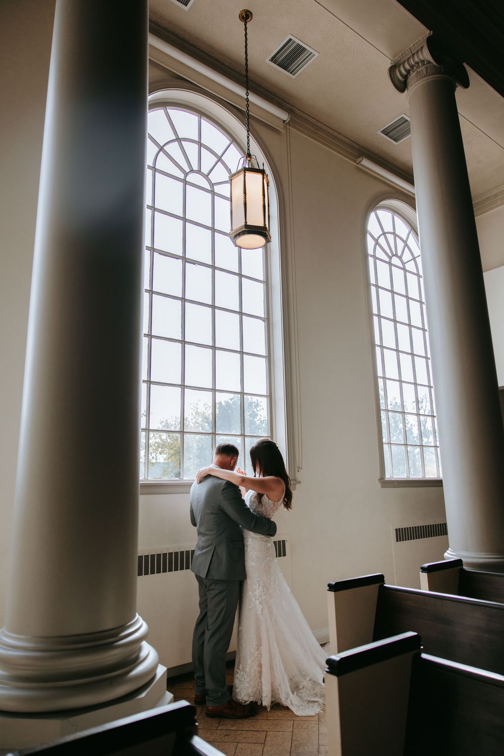 A romantic scene in a church with tall arched windows and classic architectural details.