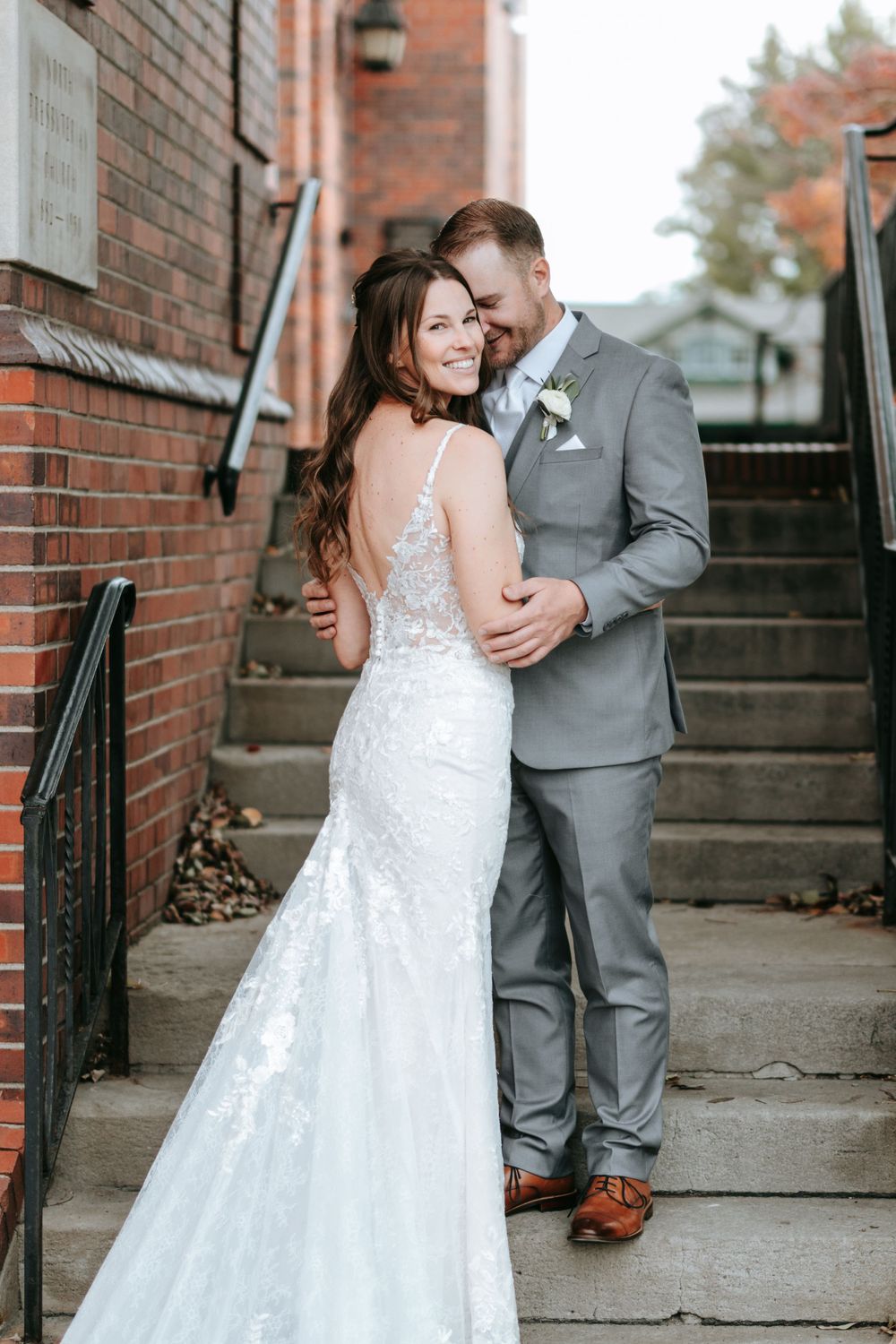 Romantic moment on vintage brick steps with classic architecture in background.