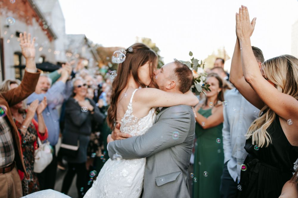 A celebratory moment with confetti and cheering guests outside a brick venue.