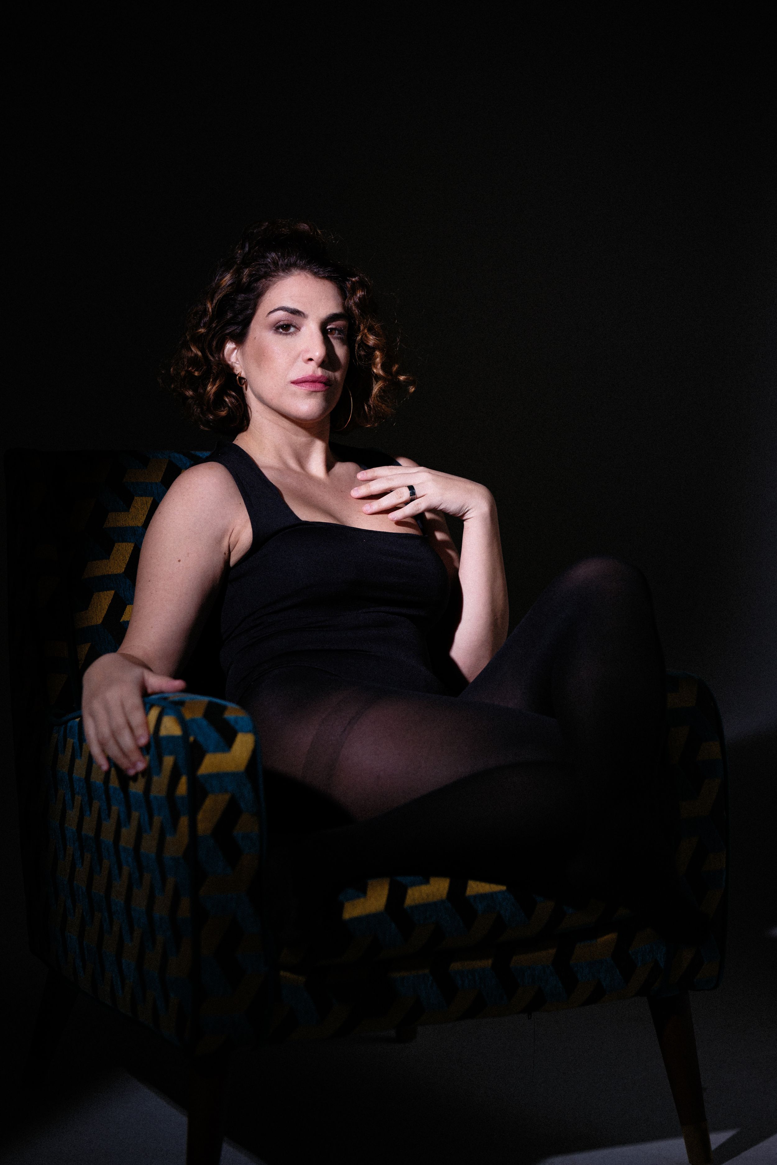 Dramatic low-key portrait on blue and yellow patterned furniture.