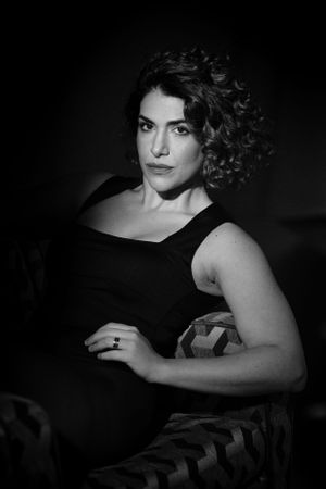 Classic black and white portrait with vintage glamour styling on patterned chair.