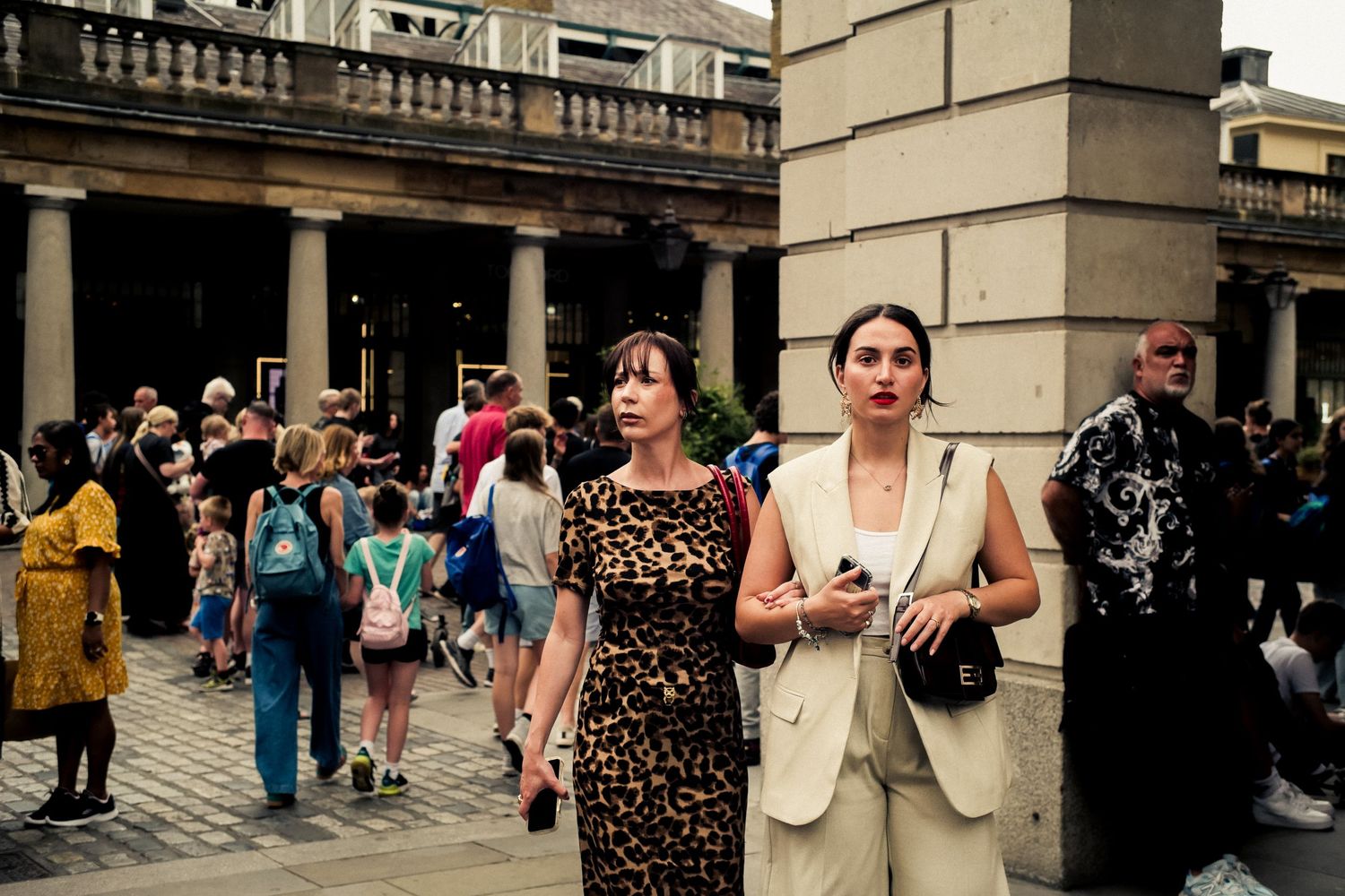 Tourists explore the historic colonnade at Bath's Roman architecture site.