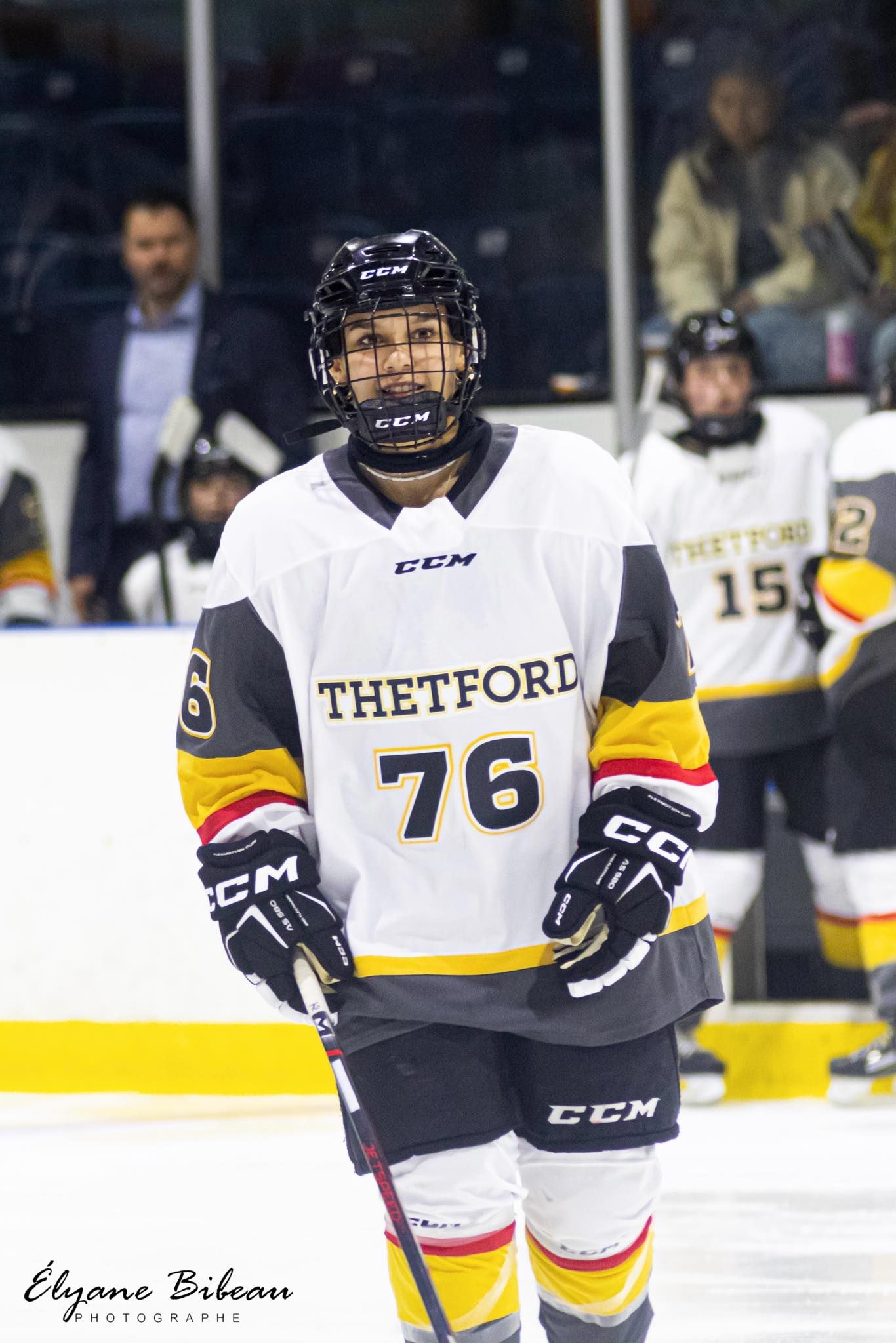 Hockey player wearing Thetford number 76 jersey standing on ice.