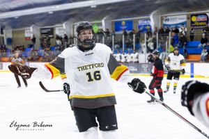 Ice hockey player wearing number 16 jersey celebrates during game action.