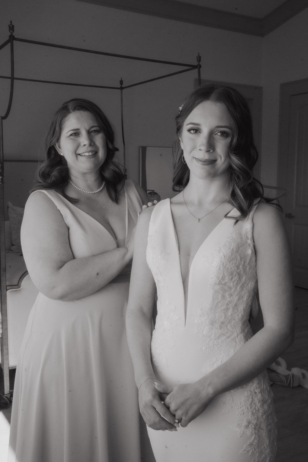 Black and white portrait of two attendants in elegant white dresses.