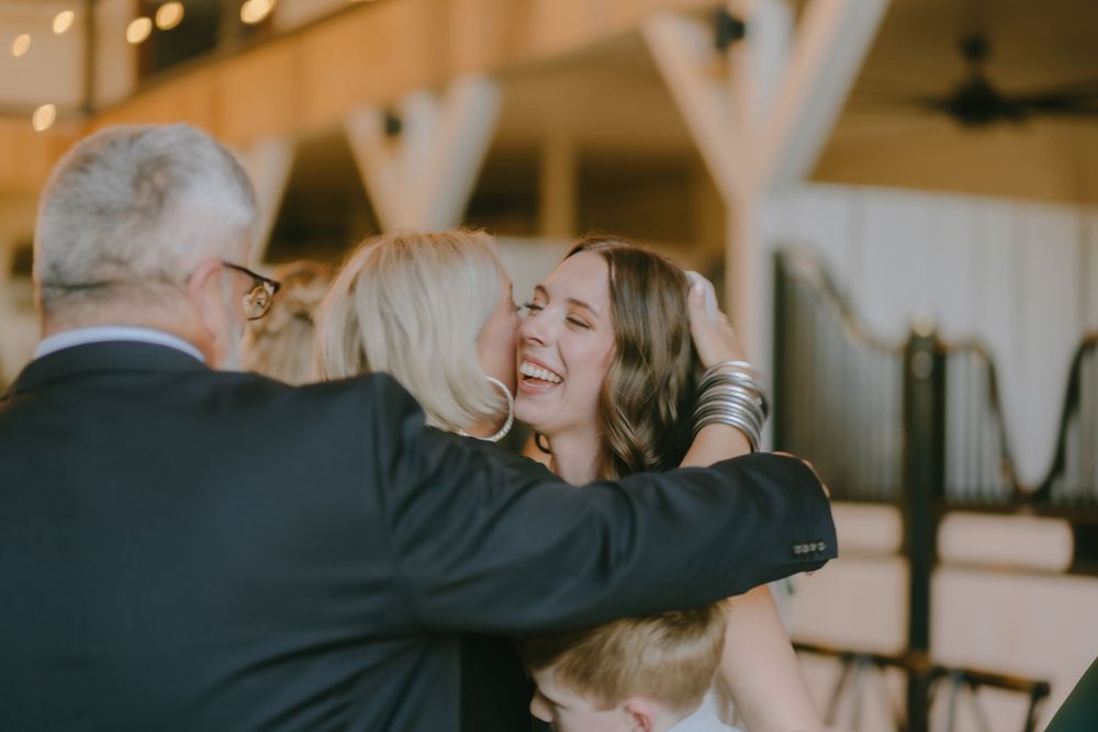 Joyful wedding reception celebration moments under ambient lighting.