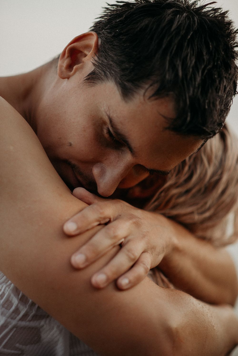 Artistic close-up photography capturing intimate skin contact in monochrome tones.