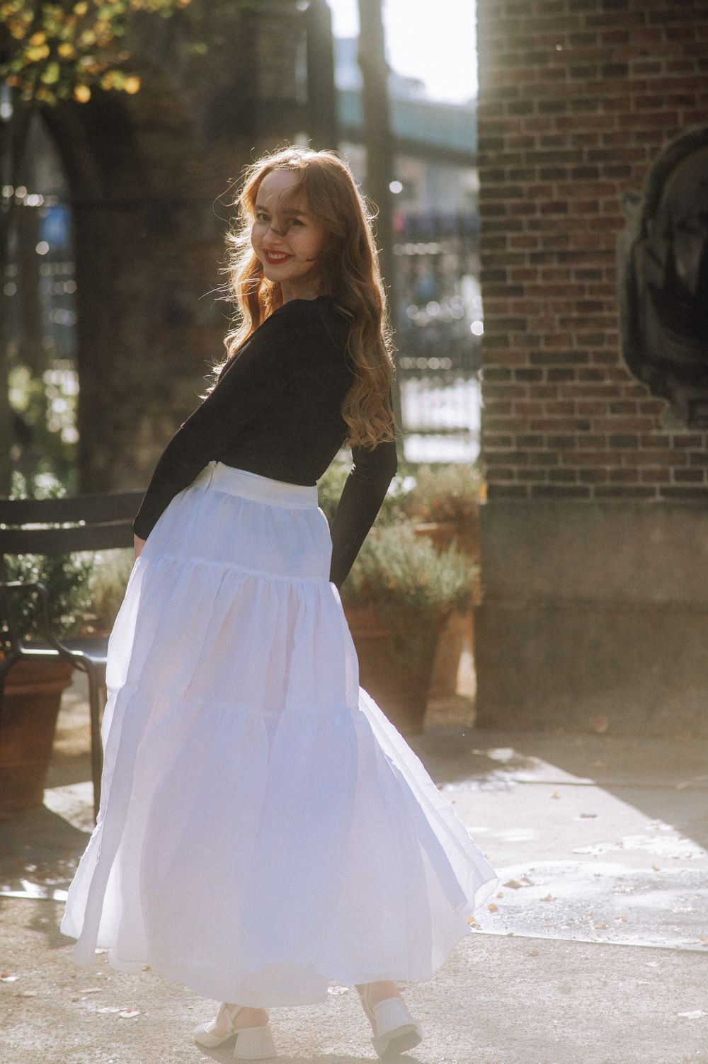 A series of ethereal shots showing a flowing white dress twirling in sunlit outdoor setting.