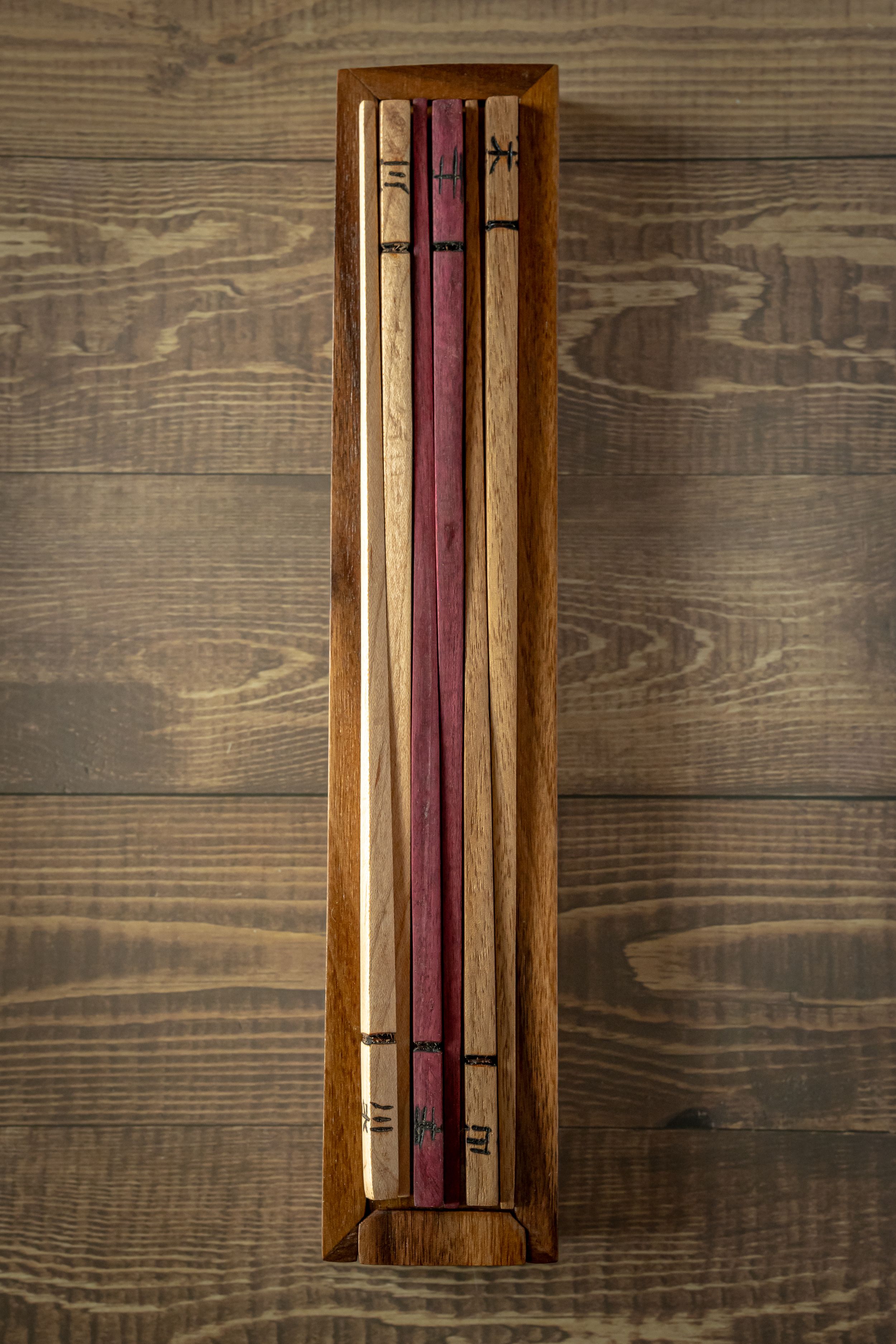 Wooden wall-mounted knife holder with magnetic strip displays rustic design against dark wood paneling.