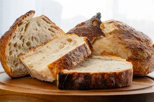 Rustic artisan sourdough bread loaves with golden brown crusts and natural scoring patterns displayed in sequence.