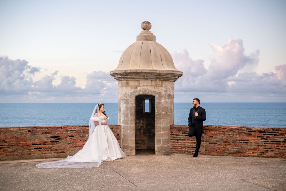 A scenic wedding photo at a historic stone garita overlooking the ocean.