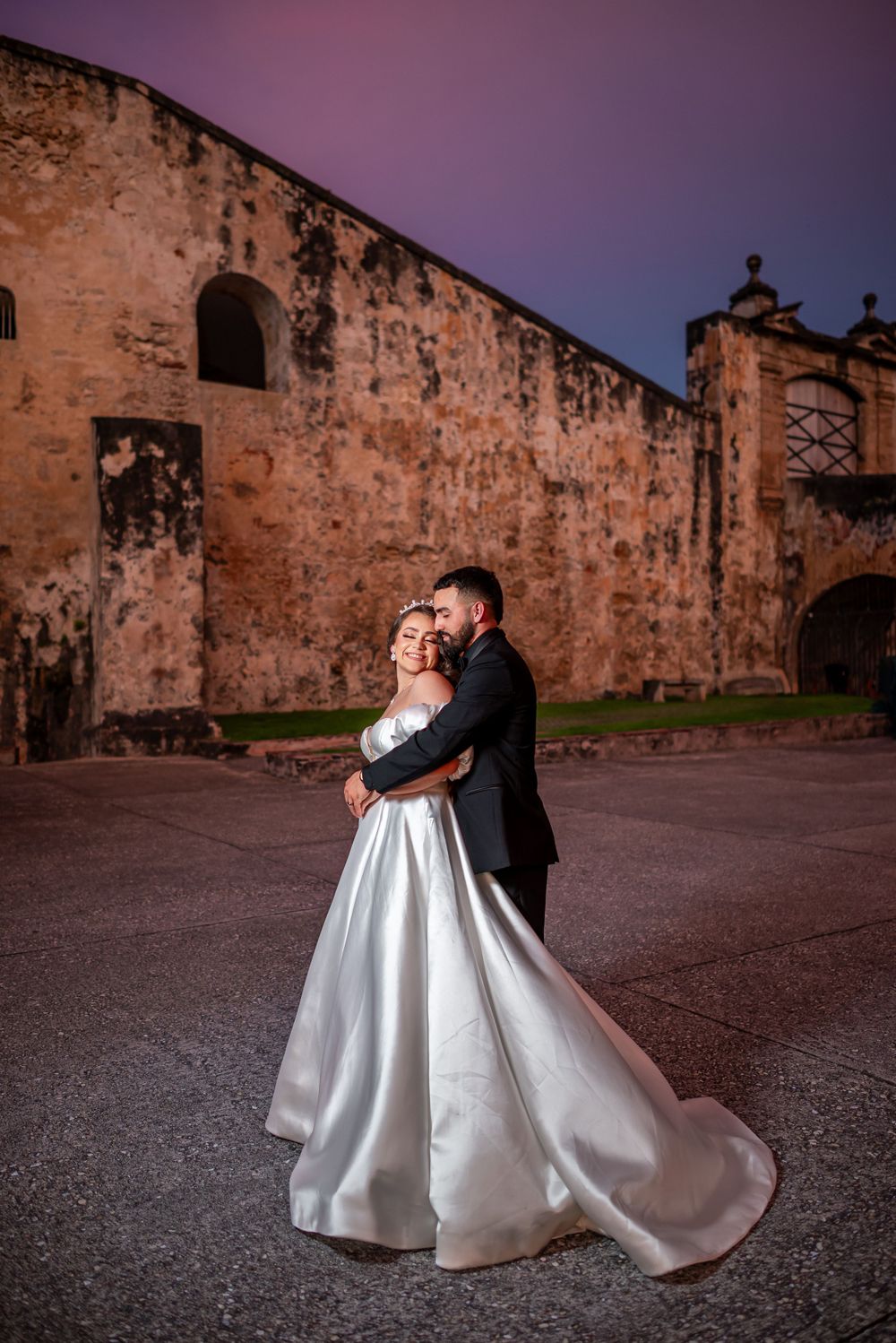 A romantic sunset wedding portrait against the backdrop of an ancient stone fortress.