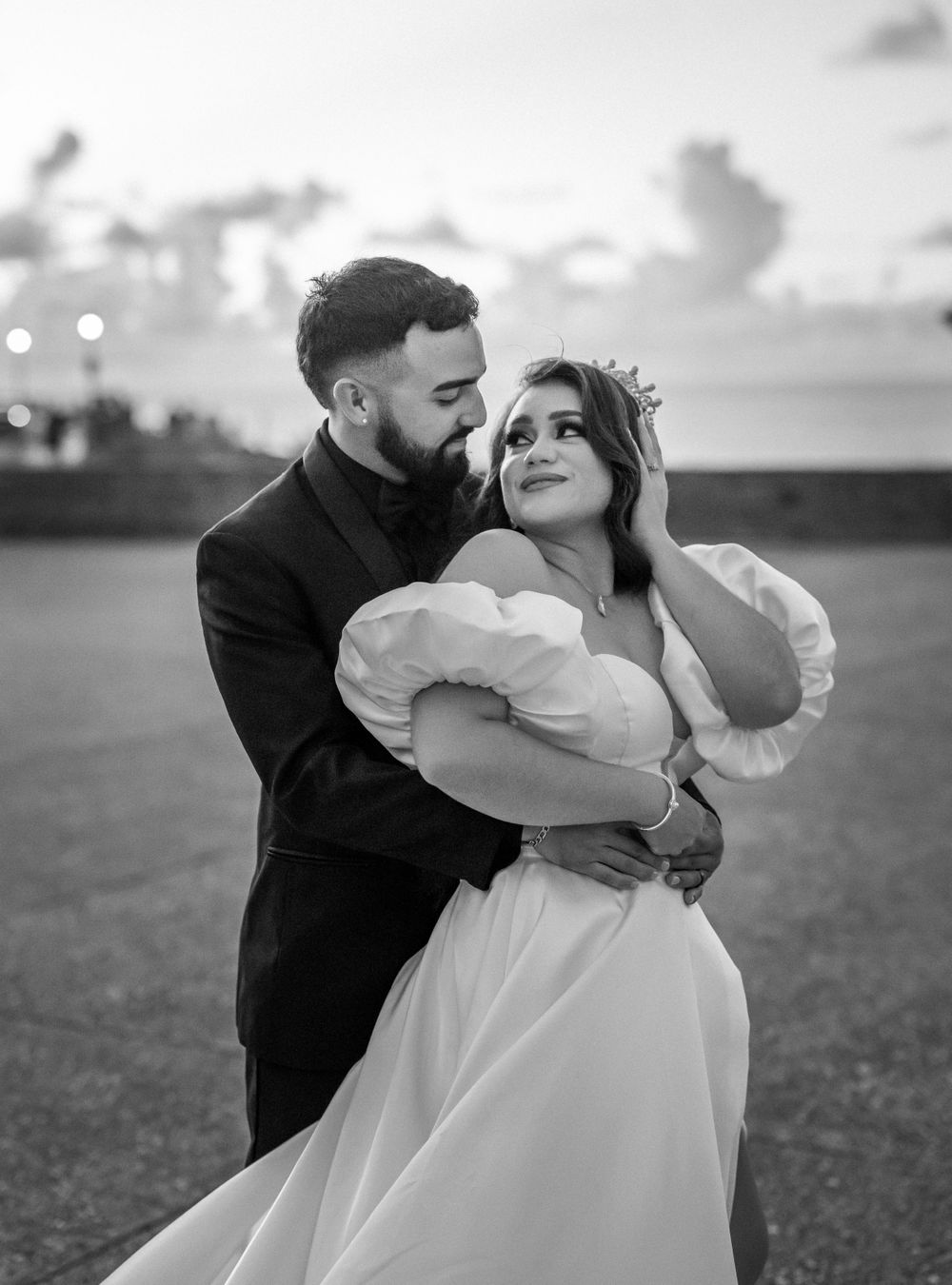 A black and white portrait of a couple sharing an intimate moment at their coastal wedding.