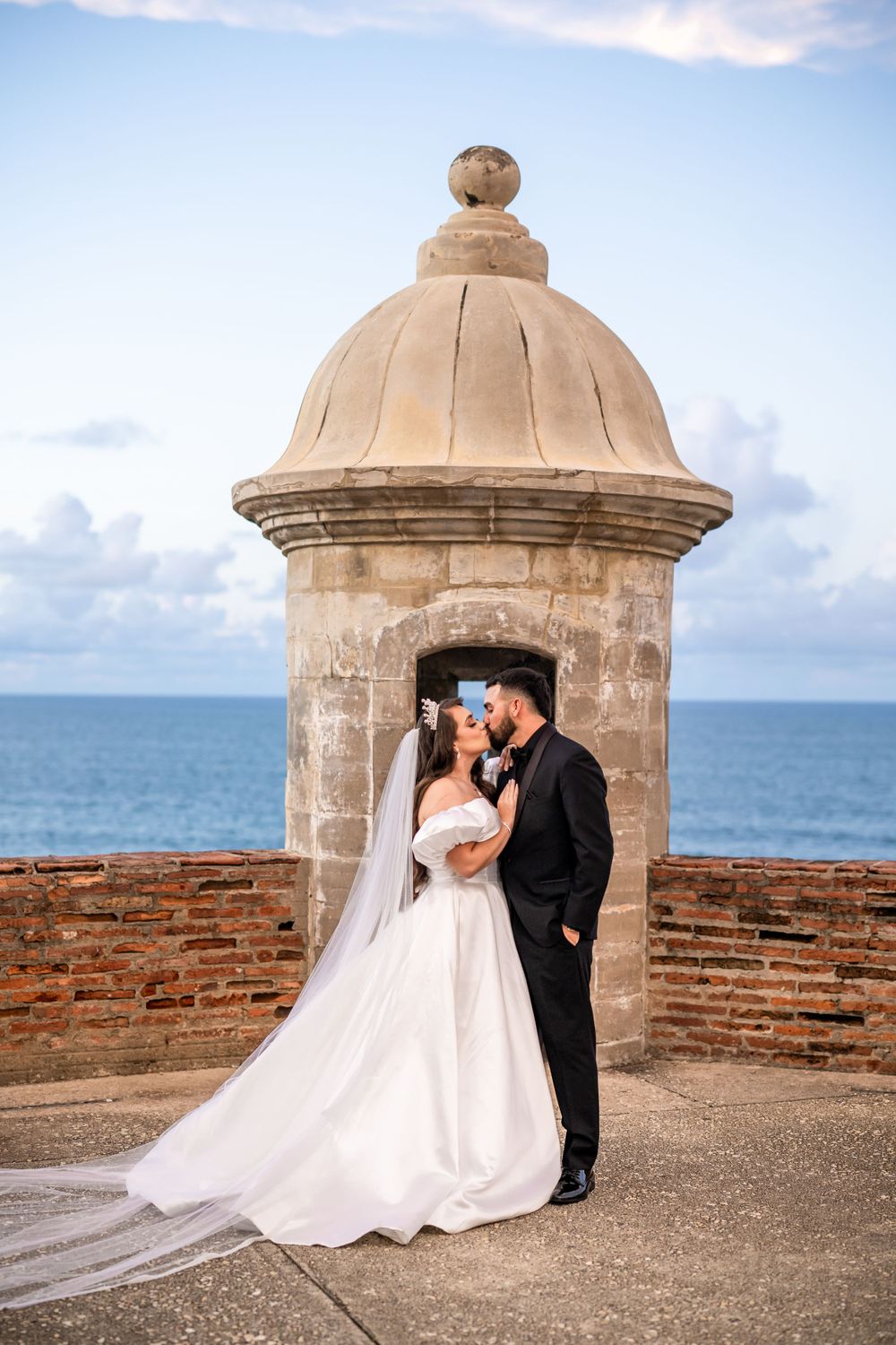 A tender wedding moment captured in a historic stone garita with ocean views.