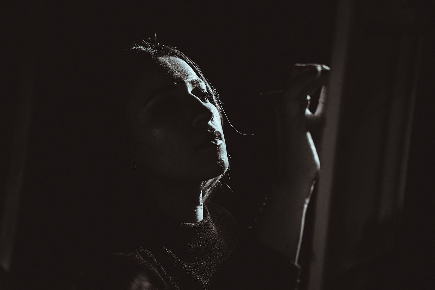 A silhouetted figure in dramatic side lighting creates a mysterious noir atmosphere.
